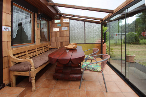 Overdækket terrasse ved Holiday home «Susanne 58 qm» i Tyskland med træbænk, bord og udsigt.