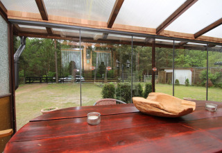 Vista desde la terraza cubierta en Holiday home Susanne 58 qm, con mesa de madera y jardín en Alemania.