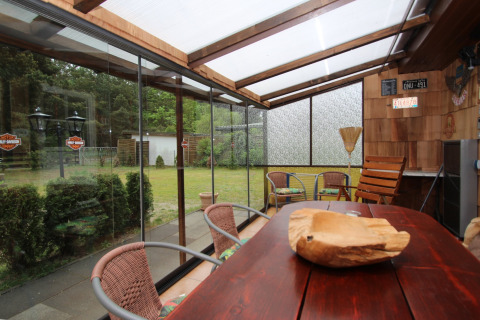 Veranda accogliente nella Holiday home Susanne in Germania, con tavolo in legno e vista sul giardino.