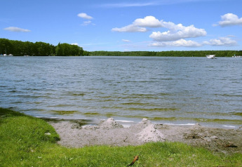 Udsigt over søen ved Holiday home «Susanne 58 qm» i Tyskland, med grøn græsplæne og blå himmel.