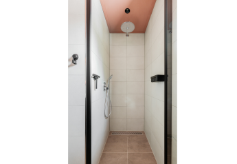 Modern shower at Forest villa «De Bosburcht» in De Kremmer, Netherlands, featuring stylish tiles and fixtures.