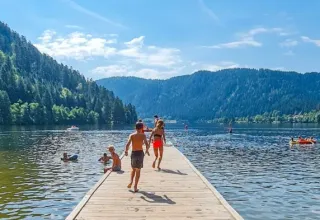 Des enfants et familles profitent d'une journée ensoleillée au bord d'un lac près de Gerbépal, Grand Est, France.