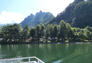 Vista sul lago, sugli alberi e sulle montagne dal campeggio Belvedere, parco vacanze in Lombardia, Italia.