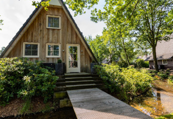 Wellness Lodge bei Hof van Salland in den Niederlanden, kleines Holzhaus mit Brücke über einen Bach.