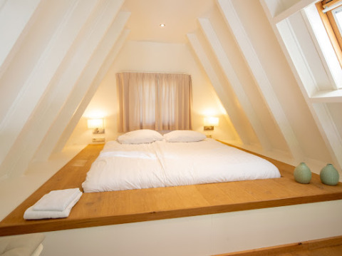 Acogedor dormitorio en Wellness Lodge en Hof van Salland, Países Bajos, con cama doble y decoración clara.