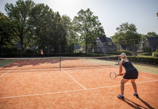Dos personas juegan tenis en una pista exterior de Wellness Lodge, Hof van Salland, Países Bajos.