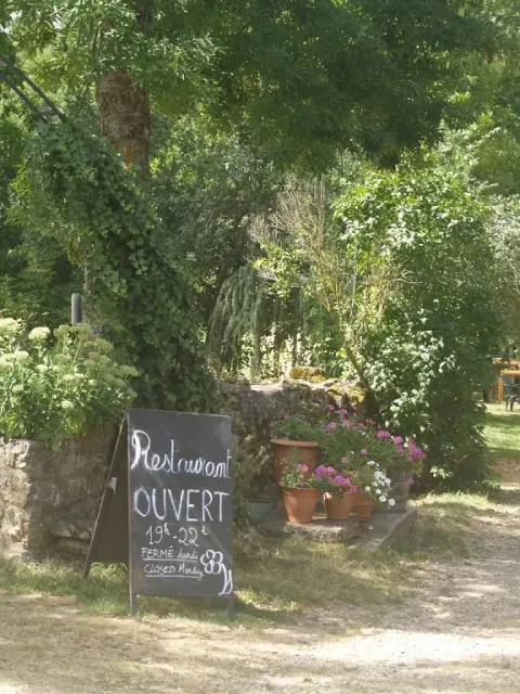 Panneau extérieur au Domaine de Pradines, parc de vacances en Occitanie, France, indiquant les horaires du restaurant.