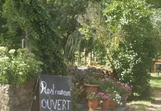 Cartel exterior en Domaine de Pradines, parque vacacional en Occitania, Francia, mostrando horarios del restaurante.