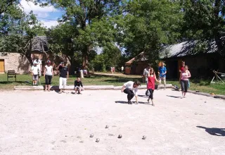 Menschen spielen Boule im Freien im Domaine de Pradines Ferienpark in Occitanie, Frankreich, bei schönem Wetter.
