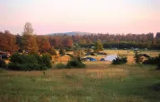 Coucher de soleil au Domaine de Pradines en Occitanie, France, avec des tentes dans un paysage champêtre.