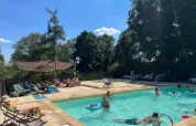 Piscine extérieure au Domaine de Pradines, Occitanie, France, avec des vacanciers détendus au soleil.