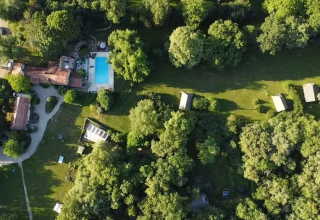 Vista aerea del campeggio Mas du Midi in Occitania, Francia, con piscina e molto verde intorno.
