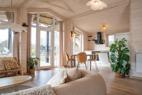 Interieur van Slowlodge bij Zomerlicht in Nederland met houten afwerking, grote ramen en veel natuurlijk licht.