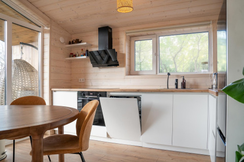 Moderne lichte houten keuken in Slowlodge bij Zomerlicht, Nederland, met veel natuurlijk daglicht.