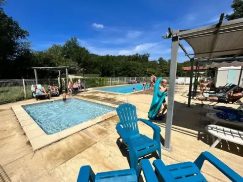 Persone che si rilassano e nuotano nelle piscine all'aperto presso il campeggio La Prade in Occitania, Francia.