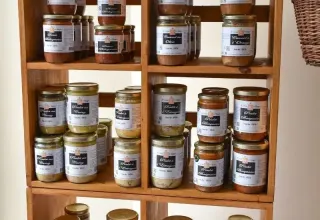 Scaffale con vasetti assortiti di conserve presso il campeggio La Prade, in Occitania, Francia.