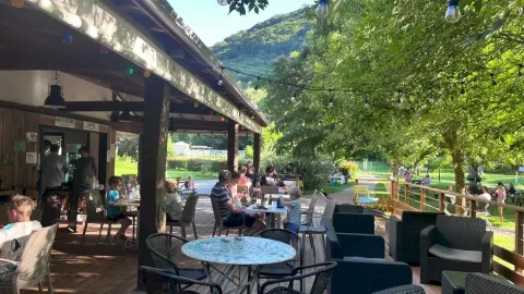 Terrazza esterna del campeggio La Prade in Occitania, Francia, immersa nel verde e nella natura.