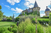 Le Domaine d'Essendieras en Nouvelle-Aquitaine, France, avec son château entouré de magnifiques jardins et ciel bleu.