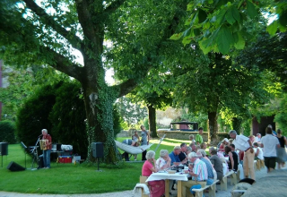 Buitengebeuren nabij Saint-Médard-d'Excideuil, Frankrijk, mensen eten onder bomen met live muziek.