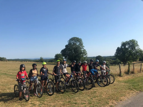 Un gruppo di ragazzi con caschi e biciclette al Domaine d'Essendieras, Nouvelle-Aquitaine, Francia, all'aperto.