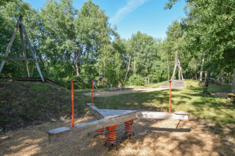 Udendørs legeplads i Domaine d' Essendieras, Nouvelle-Aquitaine, Frankrig, omgivet af træer og natur.