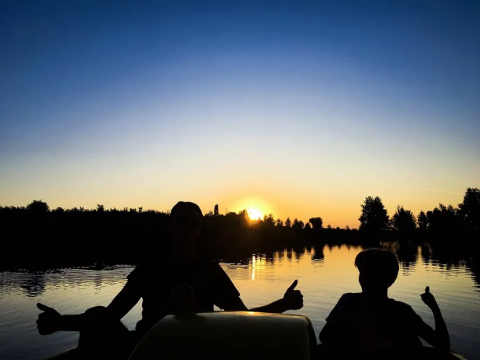 Sagome di due persone sul lago al tramonto vicino a Saint-Médard-d'Excideuil, Nouvelle-Aquitaine, Francia.