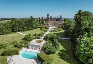 Luchtfoto van Domaine d' Essendieras vakantiepark in Nouvelle-Aquitaine, Frankrijk, met kasteel en zwembad.