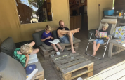 Family reading and relaxing outside a safari tent with bathroom at Domaine d'Essendieras in France.