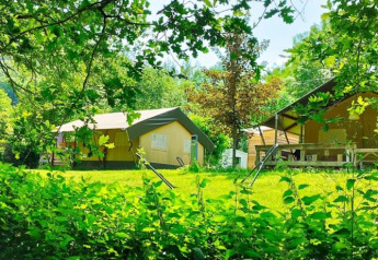 Tenda safari met badkamer al campeggio La Prade in Francia, immersa nel verde rigoglioso e nella natura.
