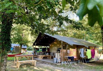 Safaritent met badkamer op Camping La Prade in Frankrijk, omgeven door groen en kampeercomfort.