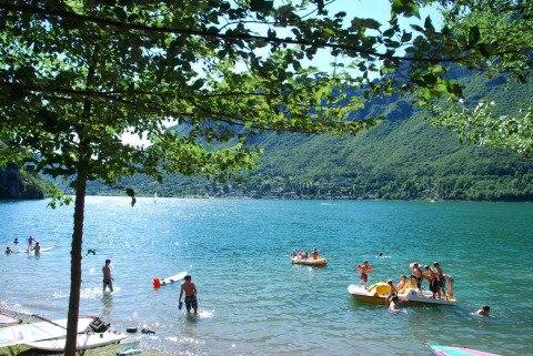 Persone si godono il sole e le attività acquatiche sul lago al Campeggio La Faz, Bourgogne-Franche-Comté, Francia.