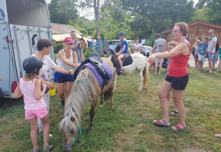 Bambini e adulti si divertono a cavalcare pony al campeggio La Faz in Borgogna-Franca Contea, Francia.