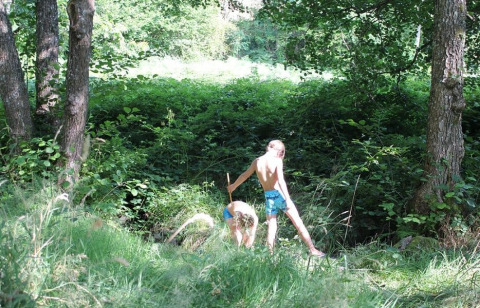 Due bambini giocano tra alberi e piante verdi al campeggio La Faz in Borgogna-Franca Contea, Francia.