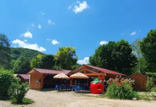 Vista esterna del campeggio La Faz nel Bourgogne-Franche-Comté, Francia, circondato da alberi verdi.