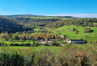 Vista del campeggio La Faz in Borgogna-Franca Contea, Francia, con colline verdi e cielo azzurro limpido.