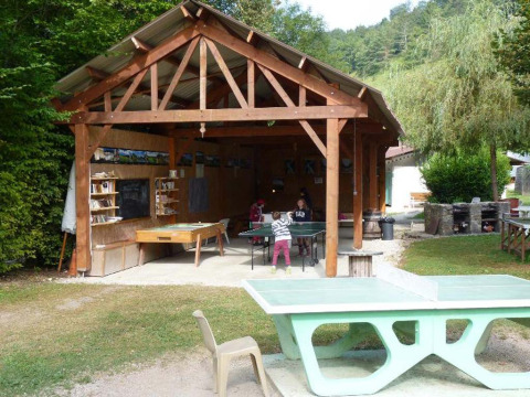 Area attività all'aperto al Campeggio La Faz in Borgogna-Franca Contea, con tavoli da ping pong e gazebo in legno.