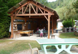 Area attività all'aperto al Campeggio La Faz in Borgogna-Franca Contea, con tavoli da ping pong e gazebo in legno.