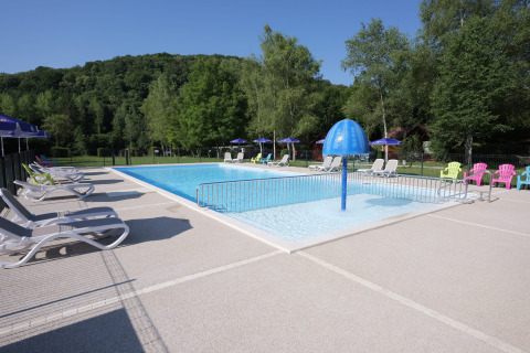 Piscina all'aperto al Campeggio La Faz in Borgogna-Franca Contea, Francia, con lettini e vegetazione intorno.