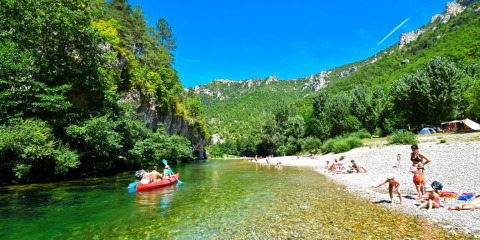 Campeggio La Faz in Bourgogne-Franche-Comté, Francia, con famiglie che nuotano e fanno canoa sul fiume.
