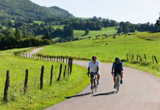 Due ciclisti percorrono una strada di campagna vicino al campeggio La Faz in Borgogna-Franca Contea, Francia.