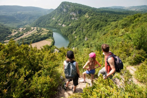 Famiglia in escursione vicino a Orgelet, Borgogna-Franca Contea, Francia, con vista su un fiume tortuoso.
