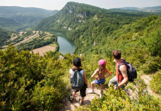 Famiglia in escursione vicino a Orgelet, Borgogna-Franca Contea, Francia, con vista su un fiume tortuoso.