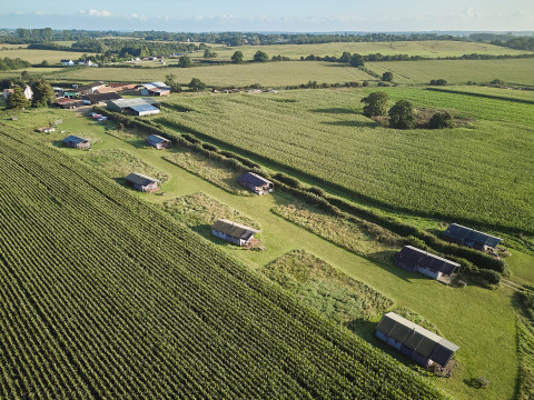 Luftaufnahme vom BoerenBed College Farm Ferienpark in Ostengland mit Zelthütten und Feldern.