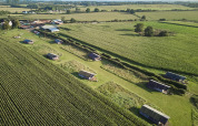Vista aerea di BoerenBed College Farm, parco vacanze nell’est dell’Inghilterra, con tende e campi verdi.