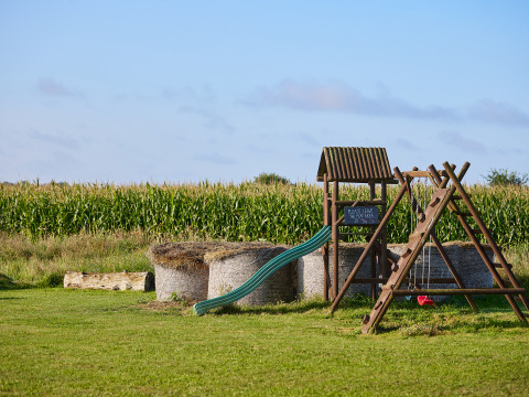 Aire de jeux avec toboggan et balançoires près d’un champ de maïs à BoerenBed College Farm, Angleterre de l’est.