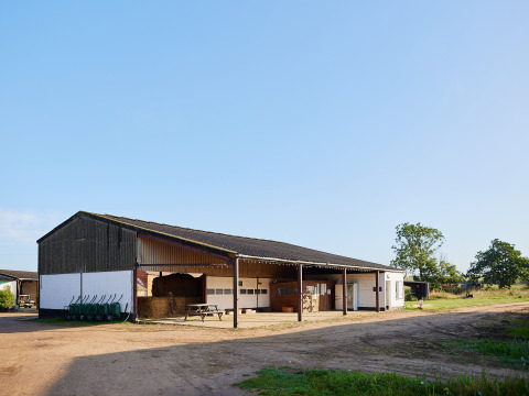 Photo of a barn at BoerenBed College Farm holiday park in East of England, United Kingdom, on a sunny day.