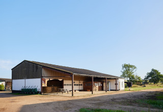 Photo of a barn at BoerenBed College Farm holiday park in East of England, United Kingdom, on a sunny day.