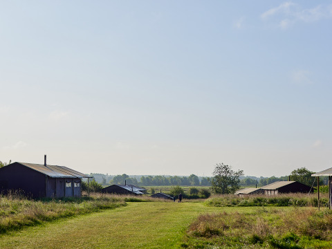 Vue sur le champ et les cabanes du parc de vacances BoerenBed College Farm dans l'Est de l'Angleterre, ciel clair.
