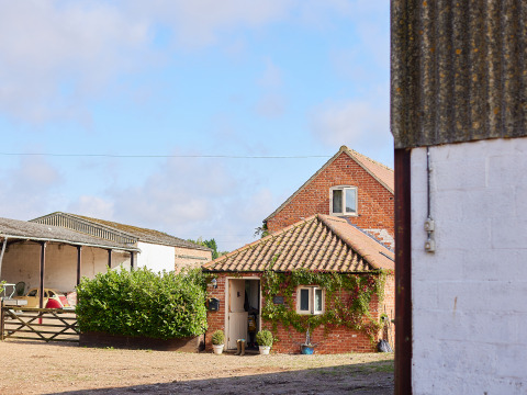 Bakstenen boerderij met klimplanten op het erf, BoerenBed College Farm, Oost-Engeland, Verenigd Koninkrijk.