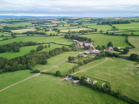 Vista aérea de los terrenos verdes y alojamientos en BoerenBed Billingsmoor Farm en el suroeste de Inglaterra, Reino Unido.